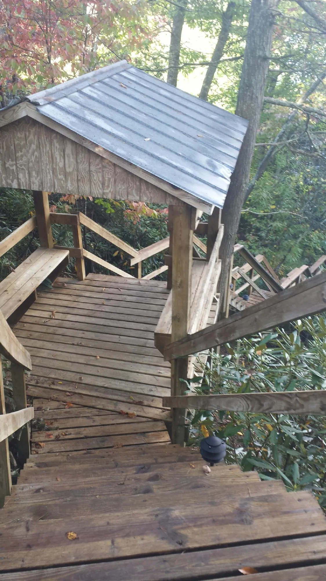 Metal roofed shelter over wooden steps on a wooded walkway — Skylight Repair & Installation work by our crew in Waldo